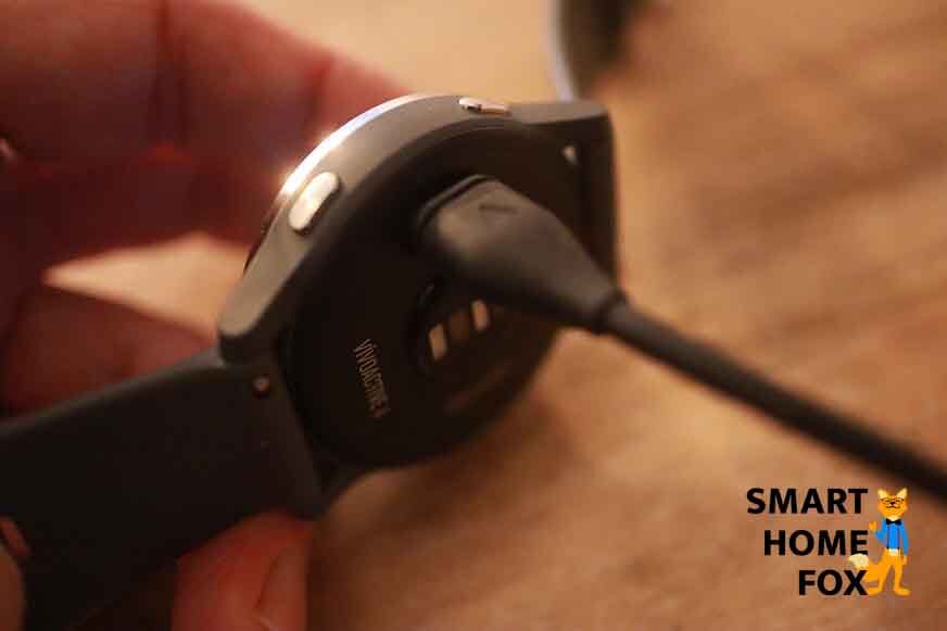 Man sieht die Garmin vivoactive 4 am Ladekabel.